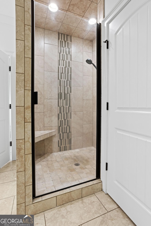 bathroom featuring tile patterned flooring and a shower stall