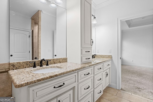 bathroom with a sink, double vanity, crown molding, and tile patterned floors