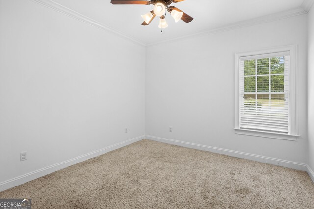 empty room featuring ceiling fan, baseboards, carpet, and ornamental molding