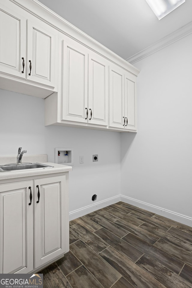 clothes washing area featuring a sink, cabinet space, crown molding, hookup for a washing machine, and dark wood-style flooring