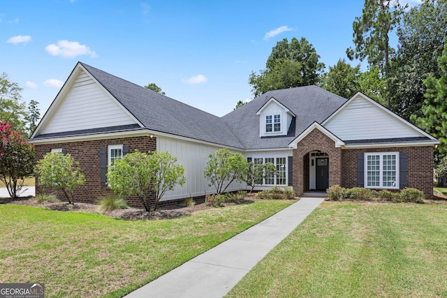 traditional-style house with brick siding, roof with shingles, and a front lawn