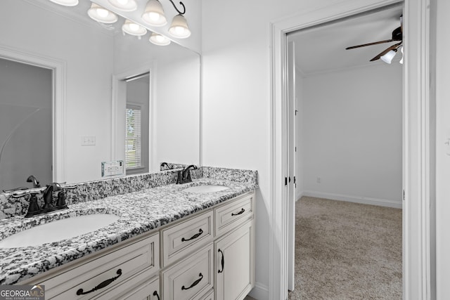 bathroom with ceiling fan, double vanity, ornamental molding, and a sink