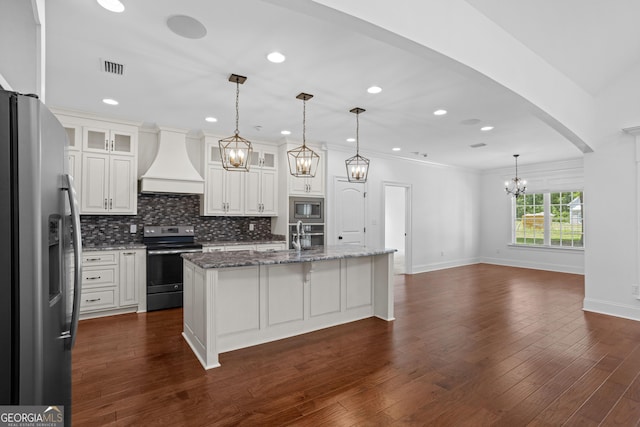 kitchen with dark wood finished floors, custom range hood, glass insert cabinets, appliances with stainless steel finishes, and backsplash