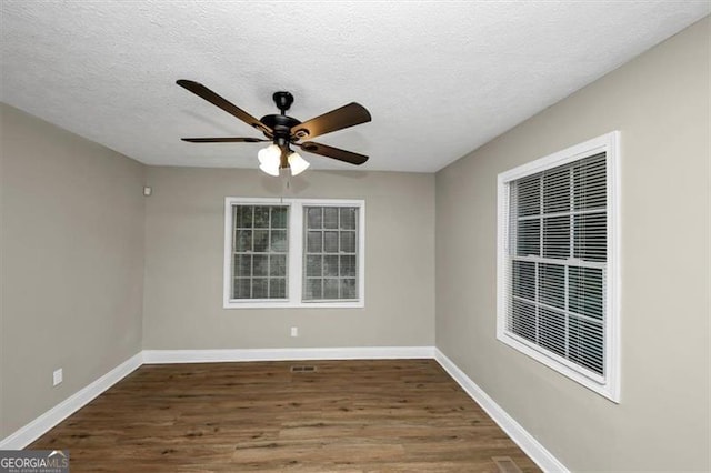 spare room with ceiling fan, dark wood-type flooring, and a textured ceiling