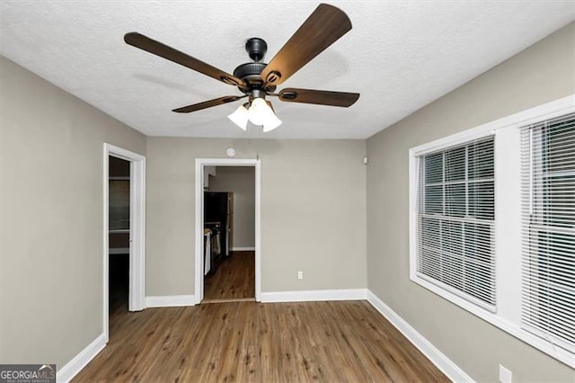 unfurnished room featuring ceiling fan, wood-type flooring, and a textured ceiling