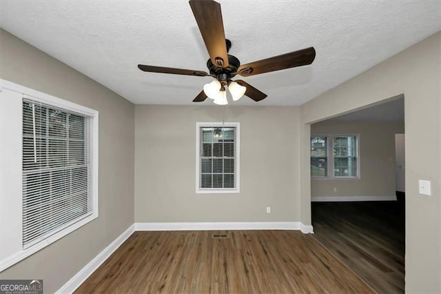 empty room with dark hardwood / wood-style floors and a textured ceiling