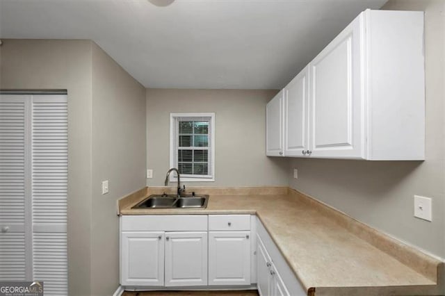 kitchen featuring white cabinetry and sink