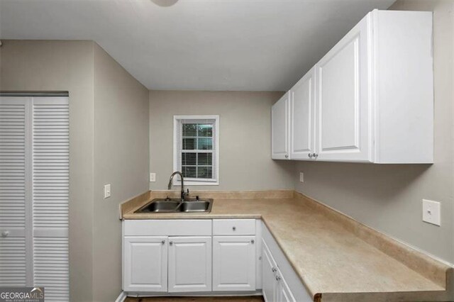 kitchen featuring white cabinetry and sink