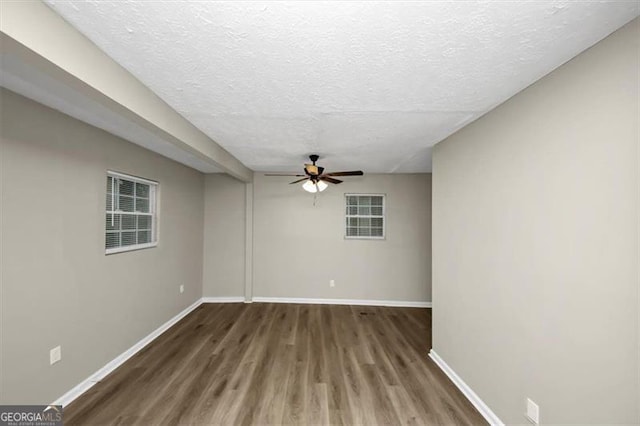 empty room featuring ceiling fan, dark hardwood / wood-style floors, and a textured ceiling