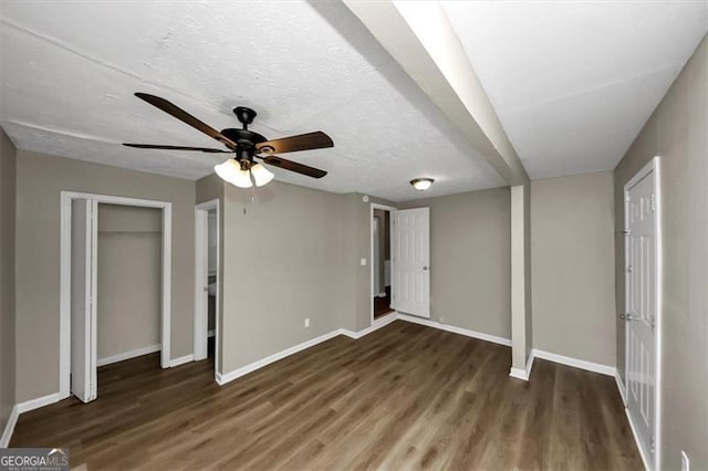 unfurnished bedroom with ceiling fan, dark hardwood / wood-style flooring, and a textured ceiling