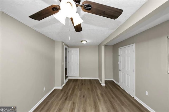 interior space featuring ceiling fan, dark hardwood / wood-style floors, and a textured ceiling