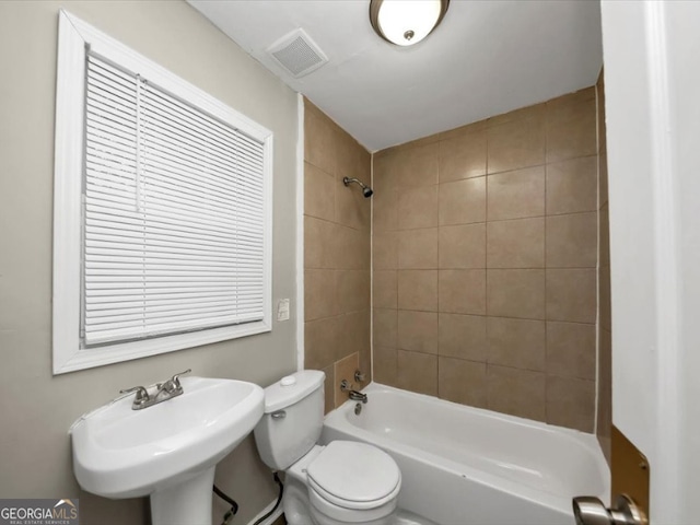 full bathroom with tiled shower / bath, sink, and toilet