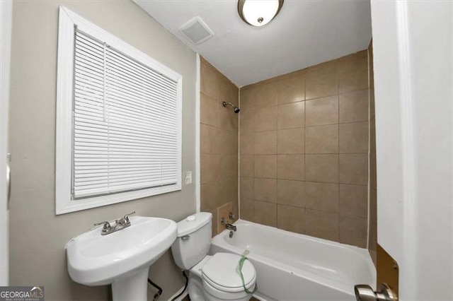 full bathroom featuring tiled shower / bath, sink, and toilet