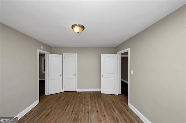 unfurnished bedroom with dark hardwood / wood-style floors and a closet