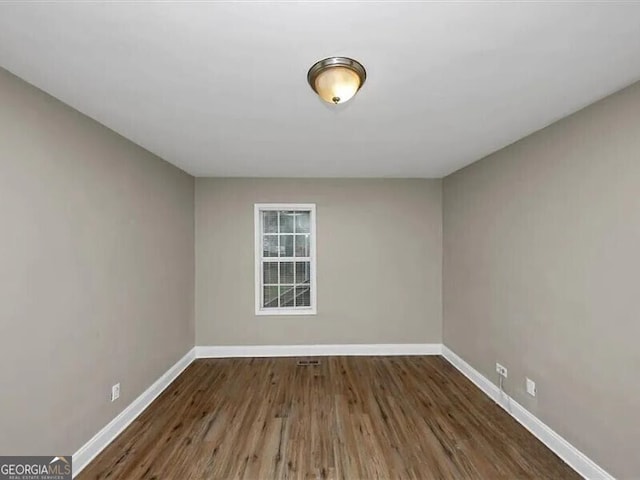 unfurnished room featuring dark hardwood / wood-style flooring