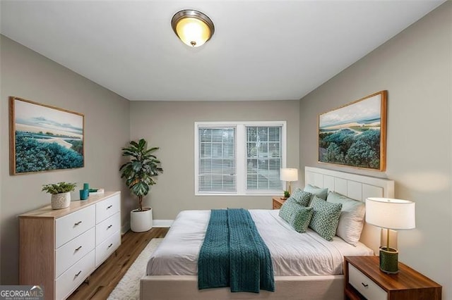 bedroom with dark hardwood / wood-style flooring