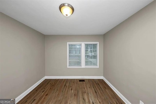 unfurnished room with dark hardwood / wood-style flooring