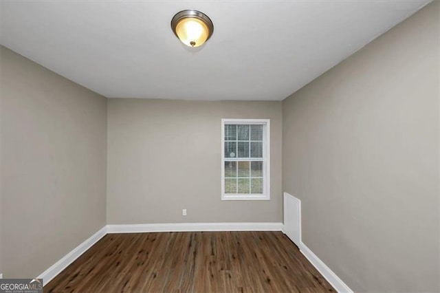 empty room with dark hardwood / wood-style flooring