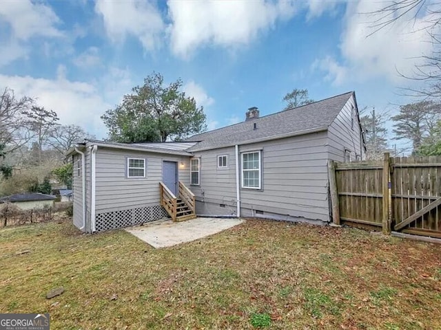 rear view of house with a yard and a patio