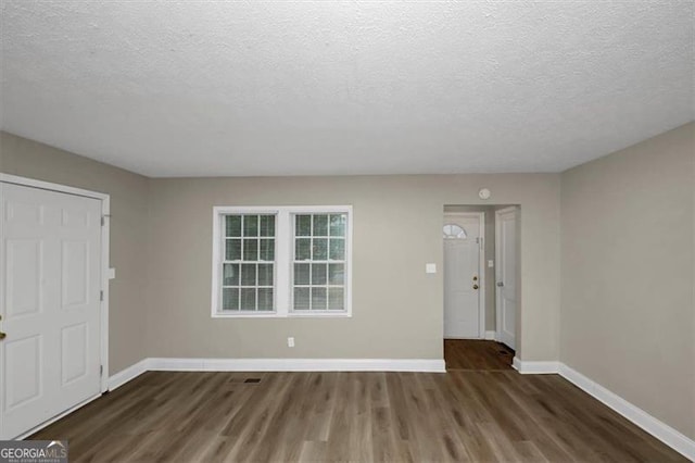 entrance foyer featuring a textured ceiling and dark hardwood / wood-style flooring