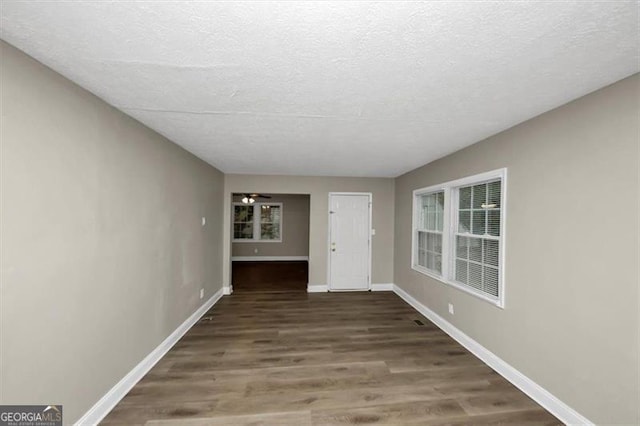 interior space with dark wood-type flooring and a textured ceiling