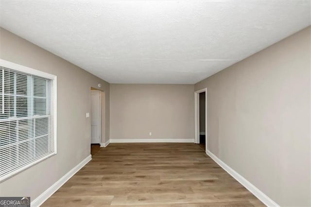 empty room with hardwood / wood-style flooring and a textured ceiling