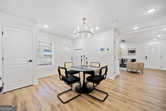 dining area featuring an inviting chandelier and light hardwood / wood-style flooring