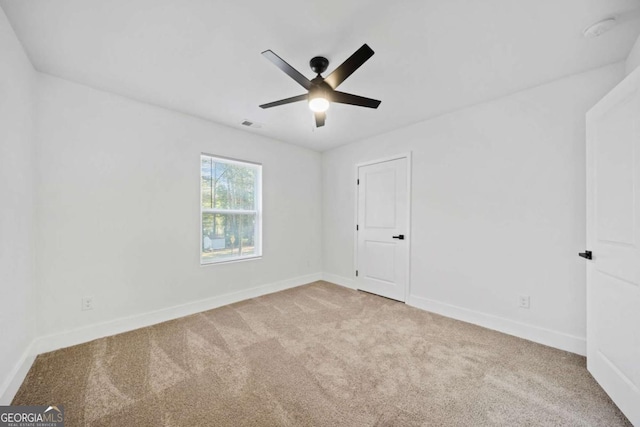 unfurnished room with light colored carpet and ceiling fan