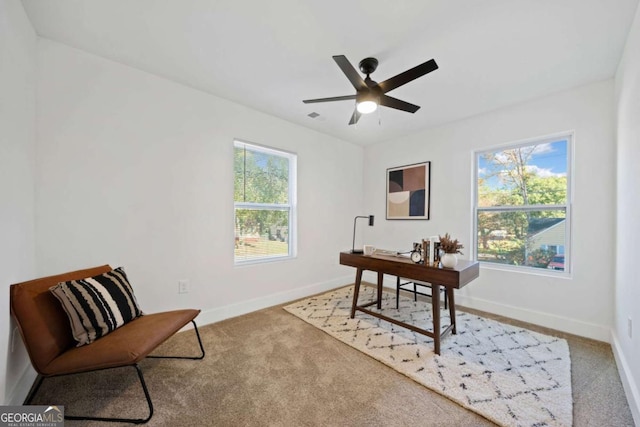 carpeted office space with ceiling fan and plenty of natural light