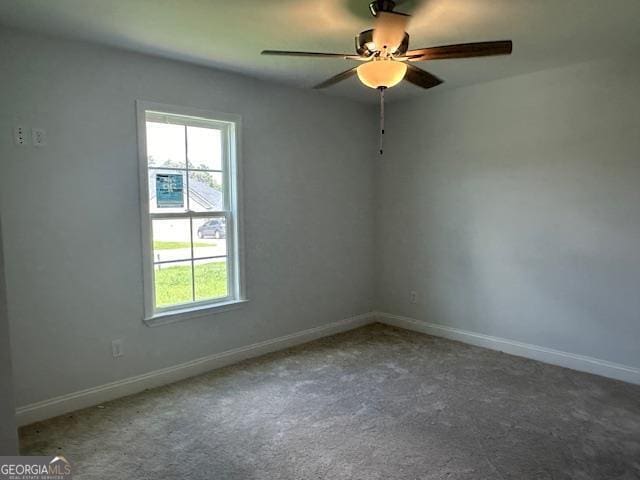 carpeted spare room with ceiling fan