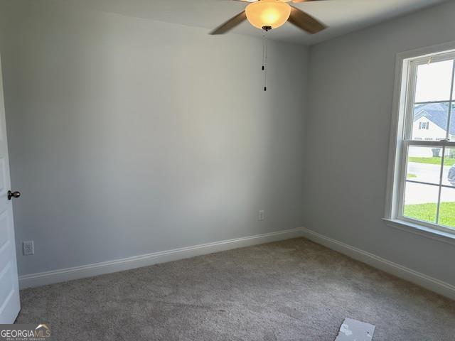 carpeted empty room featuring ceiling fan