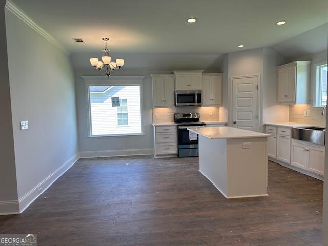 kitchen featuring pendant lighting, white cabinets, and appliances with stainless steel finishes