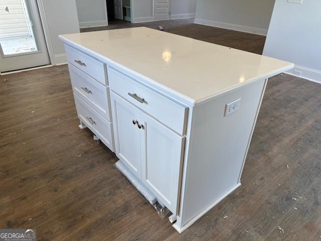 kitchen featuring white cabinetry, a center island, and dark wood-type flooring