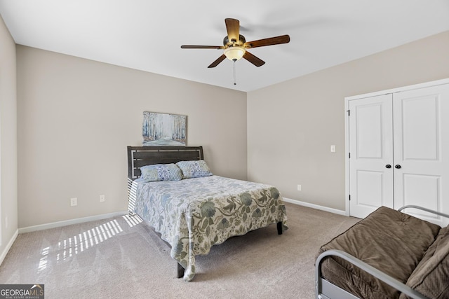 bedroom featuring light colored carpet, a closet, and ceiling fan