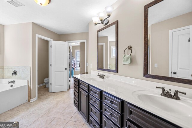 bathroom featuring tile patterned flooring, a bath, a textured ceiling, and toilet