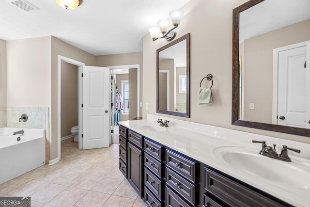 bathroom featuring toilet, visible vents, a sink, and tile patterned floors