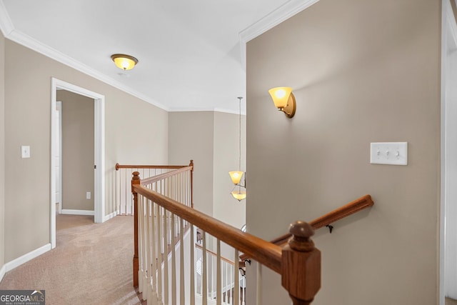 hallway featuring carpet, baseboards, crown molding, and an upstairs landing