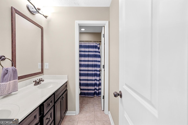 bathroom with vanity, curtained shower, tile patterned flooring, and a textured ceiling