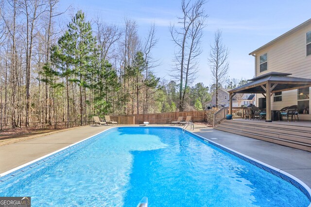 view of pool with a gazebo, a diving board, and a deck