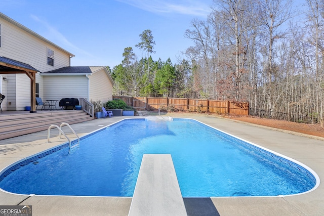 view of swimming pool with a grill, a diving board, a deck, and a patio area