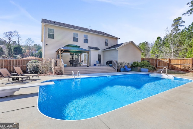 view of pool featuring a fenced backyard, a wooden deck, a fenced in pool, and a gazebo