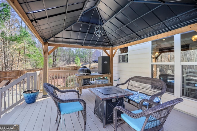 wooden terrace featuring a gazebo, an outdoor fire pit, and fence