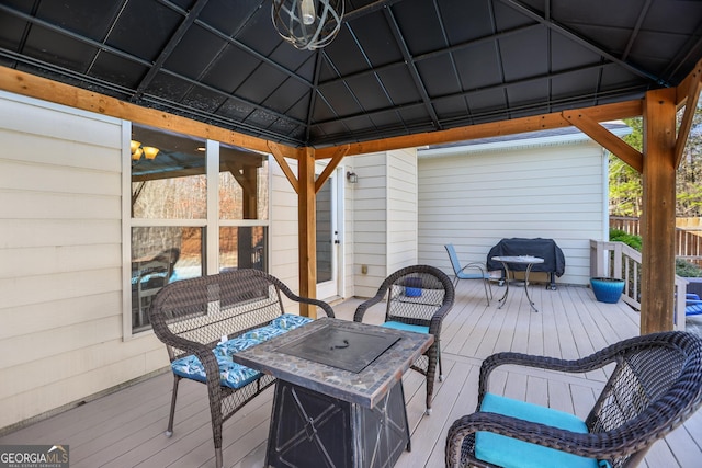 wooden deck featuring a gazebo and an outdoor living space with a fire pit