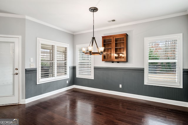 unfurnished dining area with a wainscoted wall, dark wood-style floors, visible vents, and a notable chandelier