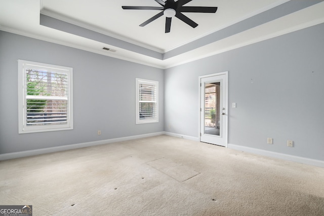 unfurnished room featuring visible vents, a raised ceiling, crown molding, and carpet flooring