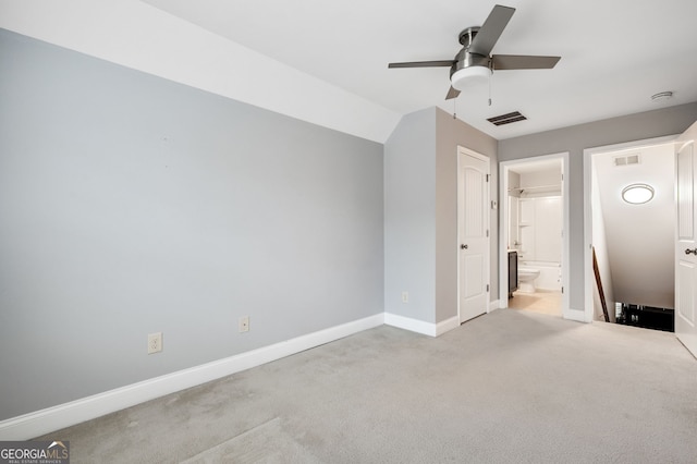 unfurnished bedroom with ensuite bath, baseboards, visible vents, and carpet flooring