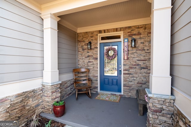 entrance to property featuring covered porch and stone siding