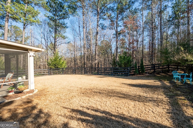 view of yard featuring fence and a sunroom