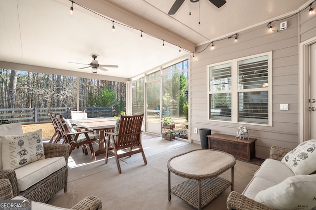 sunroom / solarium with a ceiling fan, beamed ceiling, and track lighting