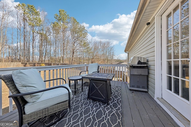 wooden terrace with a grill and an outdoor fire pit